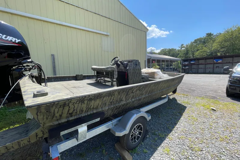 Slide: The Image of 2026 Lund 1870 Predator CC boat on trailer, parked outdoors near a building. - 4