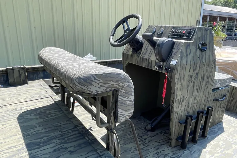 Slide: The Image of 2026 Lund 1870 Predator CC boat interior with camouflage design and steering console. - 7