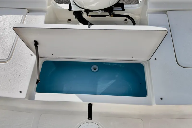 Slide: The Image of Open storage compartment on 2026 Bulls Bay 2200 boat, featuring a blue interior. - 11
