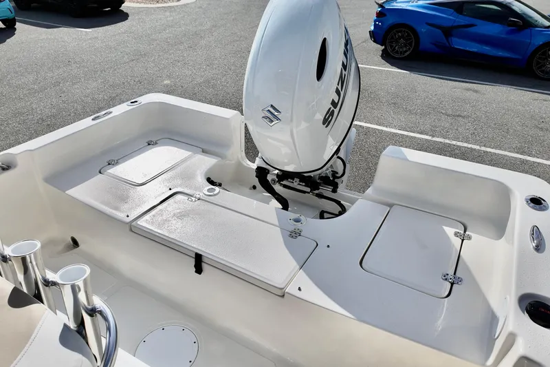 Slide: The Image of 2026 Bulls Bay 2200 boat with Suzuki outboard motor, parked near a blue sports car. - 12
