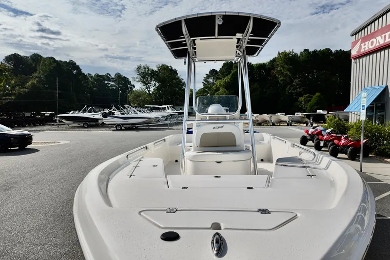 Slide: The Image of 2026 Bulls Bay 2200 boat displayed outdoors at a dealership with other vehicles. - 3