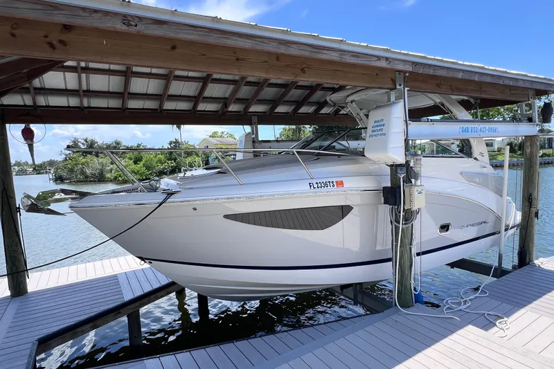 Slide: The Image of 2024 Regal 26 XO boat docked under a wooden shelter by the water. - 1