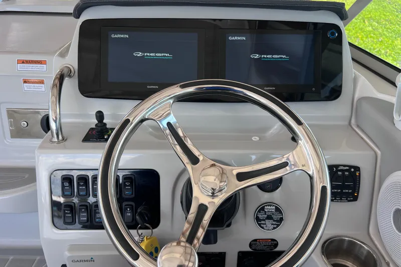 Slide: The Image of 2024 Regal 26 XO boat dashboard with Garmin displays and steering wheel. - 14