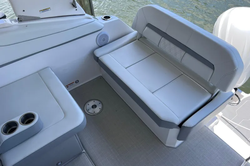 Slide: The Image of 2024 Regal 26 XO boat interior with cushioned seating and cup holders. - 15