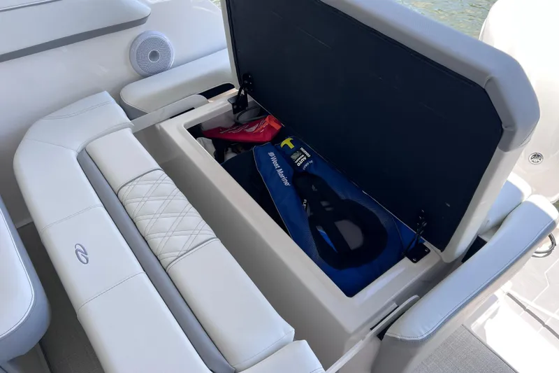 Slide: The Image of 2024 Regal 26 XO boat with open storage compartment and life jackets. - 17