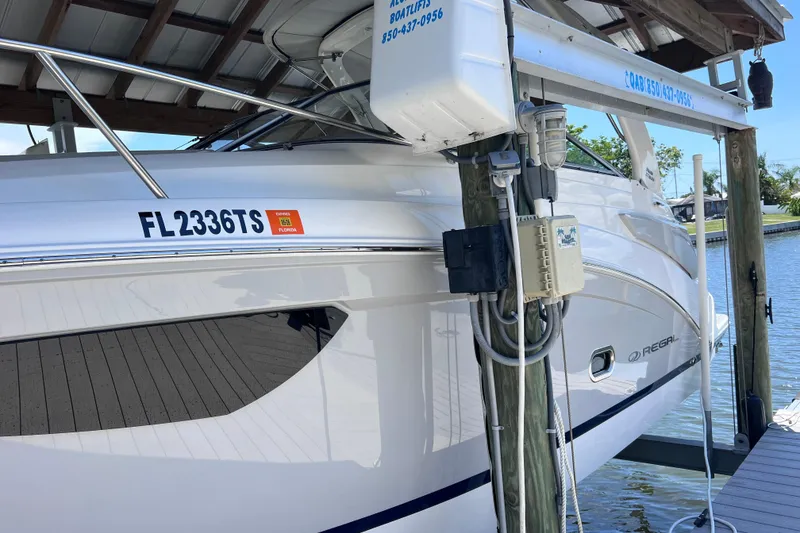 Slide: The Image of 2024 Regal 26 XO boat docked, displaying Florida registration FL2336TS. - 2
