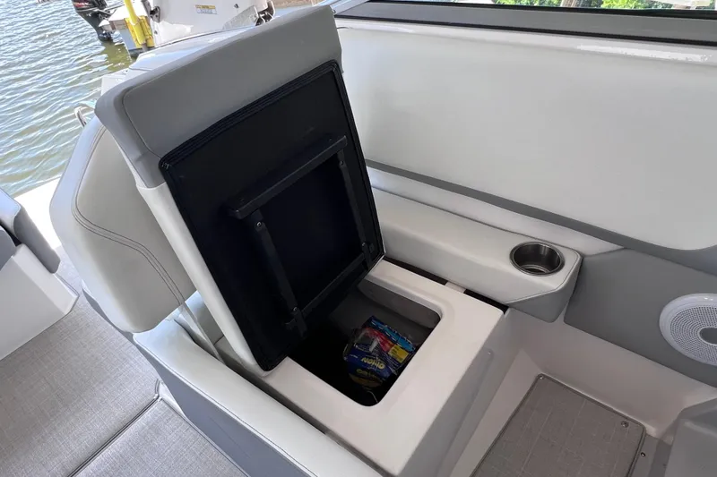 Slide: The Image of 2024 Regal 26 XO boat interior with open storage compartment and cup holder. - 22