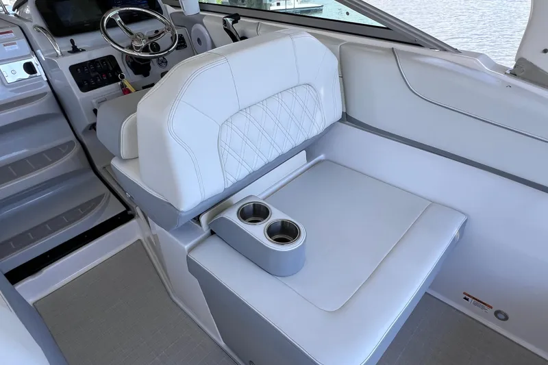 Slide: The Image of 2024 Regal 26 XO boat interior with white seating and dual cup holders. - 23
