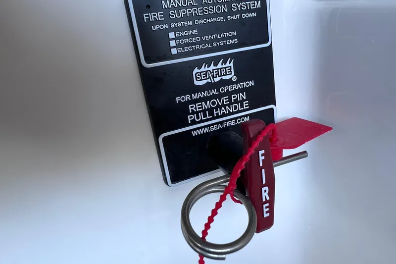 Slide: The Image of Fire suppression system handle on 2024 Regal 26 XO boat, labeled "Sea-Fire" for manual operation. - 25