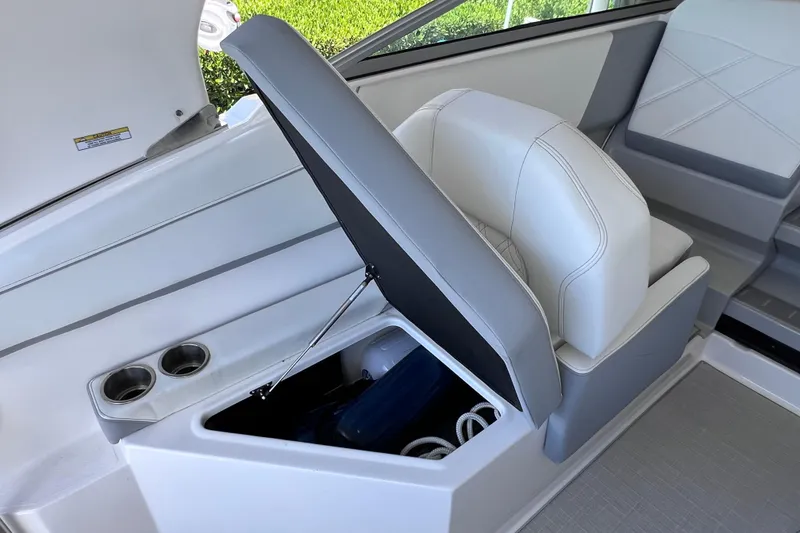 Slide: The Image of 2024 Regal 26 XO boat interior with storage compartment and cup holders. - 26