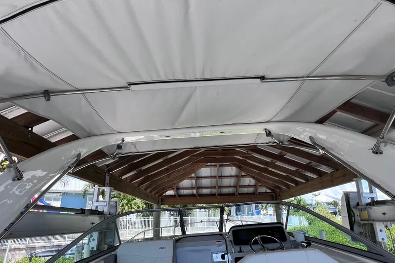 Slide: The Image of 2024 Regal 26 XO boat under a covered dock, showcasing interior and canopy. - 28