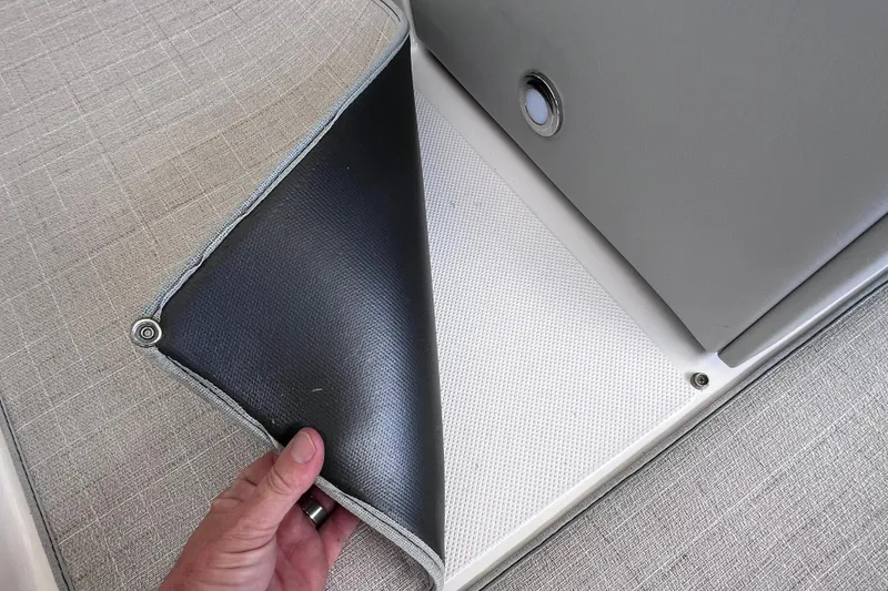 Slide: The Image of Hand lifting seat cover on 2024 Regal 26 XO boat interior. - 29