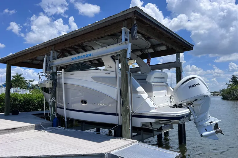 Slide: The Image of 2024 Regal 26 XO boat with Yamaha engine on lift, under blue sky. - 4