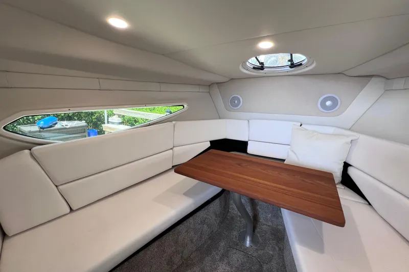 Slide: The Image of 2024 Regal 26 XO cabin interior with plush seating and wooden table. - 51