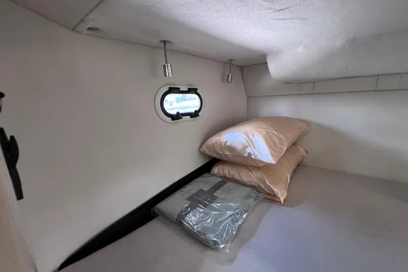 Slide: The Image of 2024 Regal 26 XO cabin interior with pillows and a small window. - 60