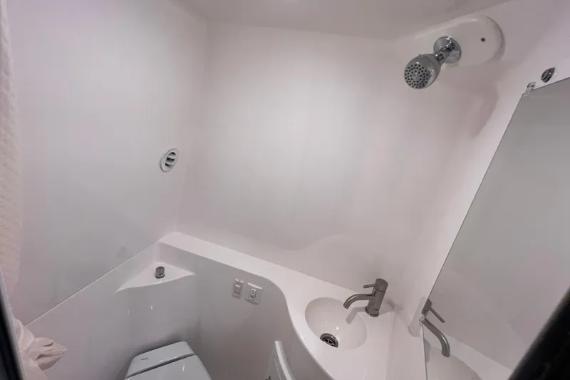 Slide: The Image of 2024 Regal 26 XO boat bathroom with shower, sink, and toilet in compact design. - 63