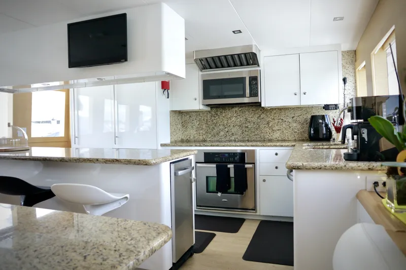 Slide: The Image of Modern kitchen interior on 2002 Hatteras 92 Cockpit Motor Yacht with granite countertops. - 16