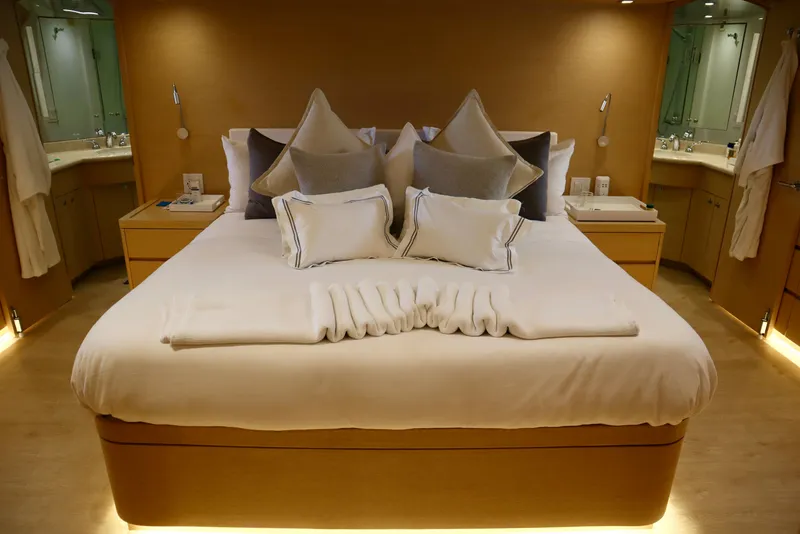 Slide: The Image of Luxurious bedroom interior on 2002 Hatteras 92 Cockpit Motor Yacht, featuring elegant bedding and ambient lighting. - 18