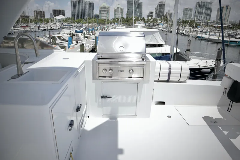 Slide: The Image of Outdoor kitchen on 2002 Hatteras 92 Cockpit Motor Yacht, featuring a grill and sink. - 29