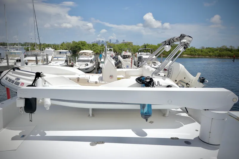 Slide: The Image of Hatteras 92 Cockpit Motor Yacht 2002 docked, featuring a spacious deck and tender. - 30