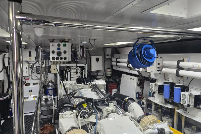 Slide: The Image of Engine room of 2002 Hatteras 92 Cockpit Motor Yacht, featuring complex machinery and control panels. - 38