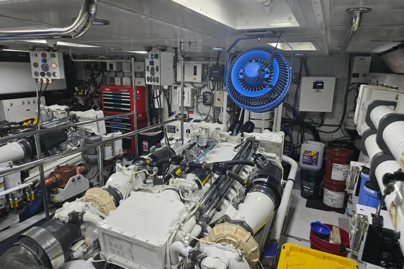 Slide: The Image of Engine room of a 2002 Hatteras 92 Cockpit Motor Yacht, featuring complex machinery and tools. - 39