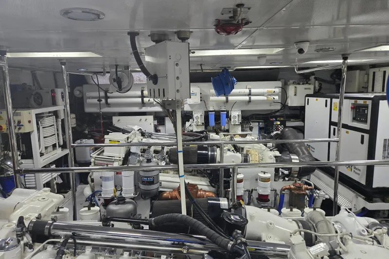 Slide: The Image of Engine room of a 2002 Hatteras 92 Cockpit Motor Yacht, showcasing complex machinery and equipment. - 42