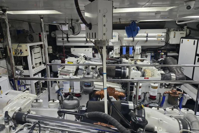 Slide: The Image of Engine room of a 2002 Hatteras 92 Cockpit Motor Yacht, showcasing complex machinery and equipment. - 43