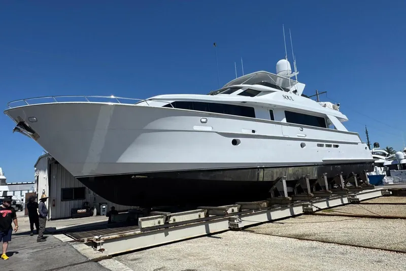 Slide: The Image of 2002 Hatteras 92 Cockpit Motor Yacht on dry dock under clear blue sky. - 51