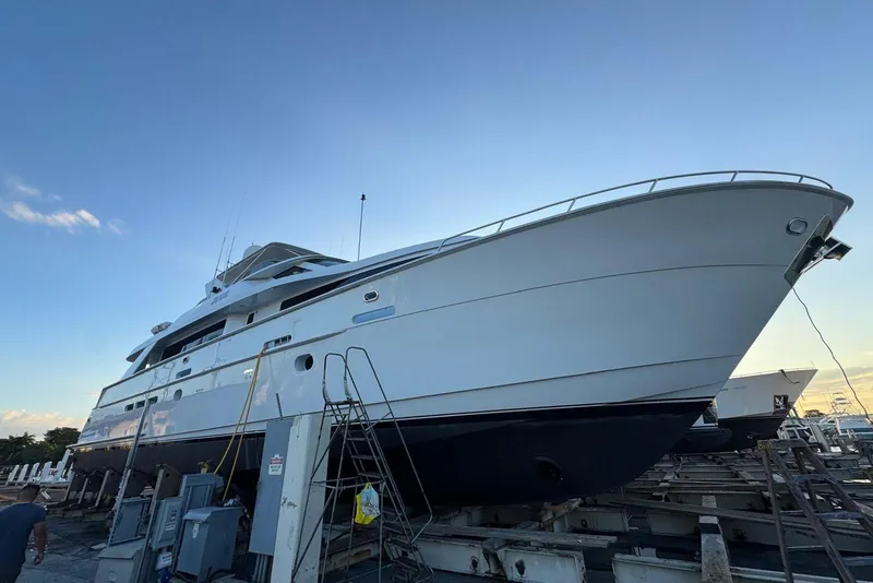 Slide: The Image of 2002 Hatteras 92 Cockpit Motor Yacht on dry dock, side view at sunset. - 53