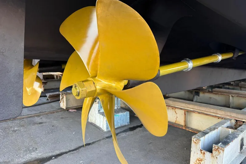 Slide: The Image of Propeller of 2002 Hatteras 92 Cockpit Motor Yacht on dry dock, showcasing its polished blades. - 58