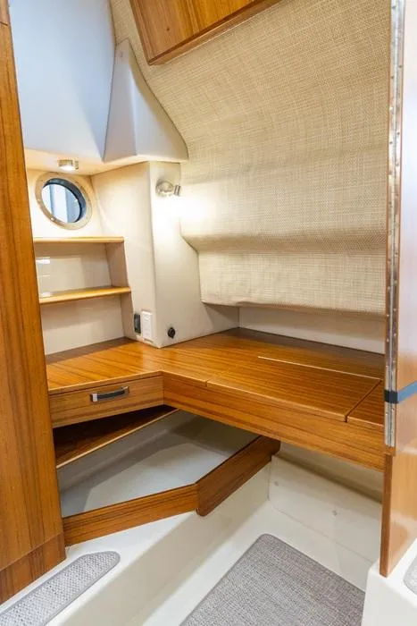 Slide: The Image of 2025 Ranger Tugs 43 Command Bridge cabin interior with wooden finish and shelving. - 32