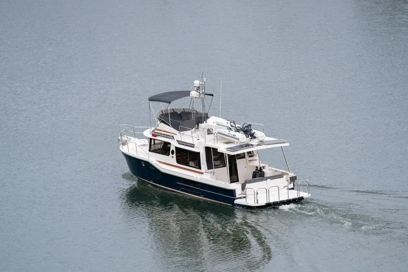 Slide: The Image of 2025 Ranger Tugs 43 Command Bridge cruising on calm water. - 9