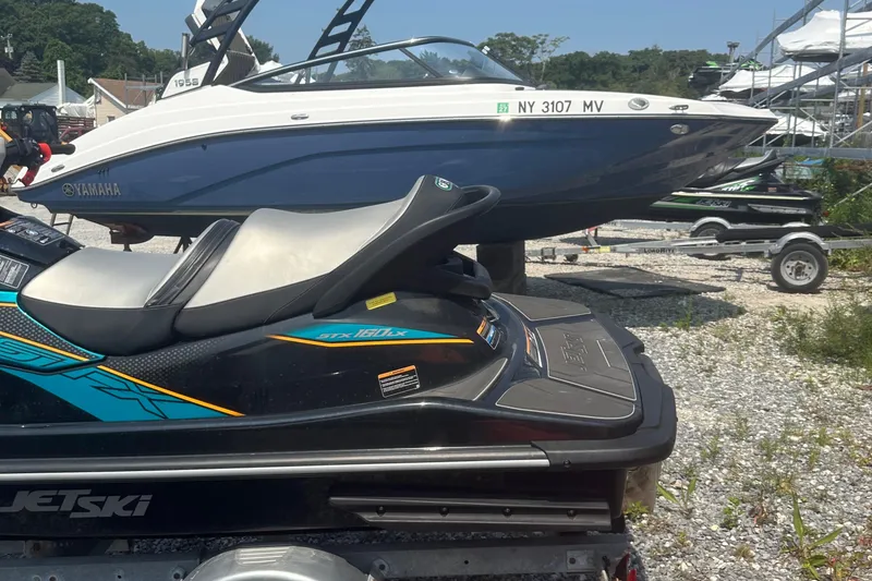 Slide: The Image of 2022 Kawasaki Jetski STX 160LX parked near a Yamaha boat on gravel. - 4