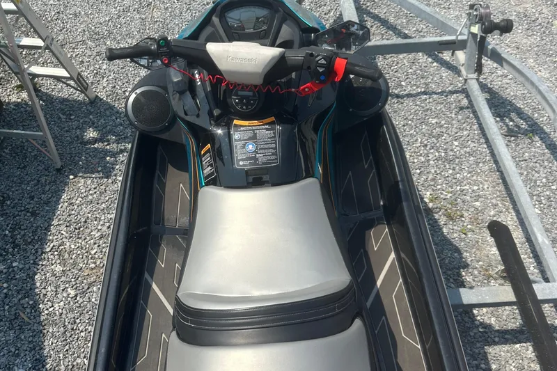 Slide: The Image of 2022 Kawasaki Jetski STX 160LX on gravel, top view of seat and controls. - 6