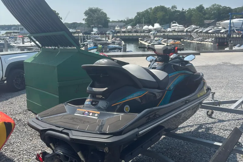 Slide: The Image of 2022 Kawasaki Jetski STX 160LX on trailer at marina, surrounded by boats. - 9