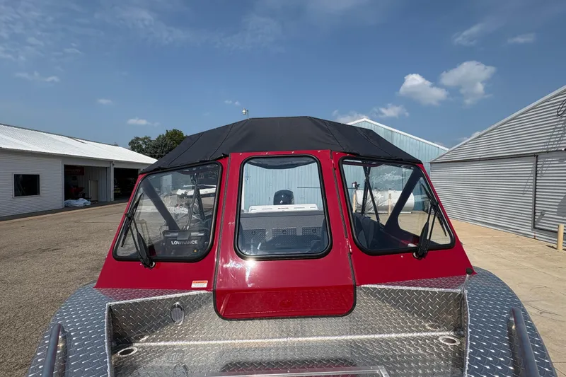 Slide: The Image of 2026 Lund 185 HG boat with red cabin and diamond plate deck under blue sky. - 10