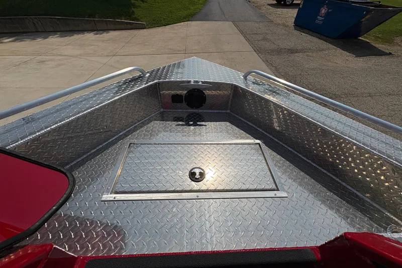 Slide: The Image of 2026 Lund 185 HG boat with diamond plate deck, parked on concrete. - 12