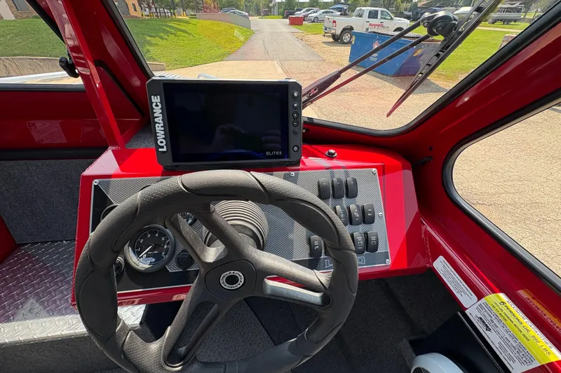 Slide: The Image of 2026 Lund 185 HG boat dashboard with Lowrance Elite display and steering wheel. - 17