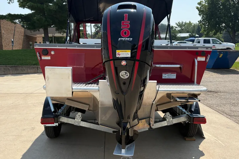 Slide: The Image of 2026 Lund 185 HG boat with 150 Pro outboard motor, parked on a trailer. - 3