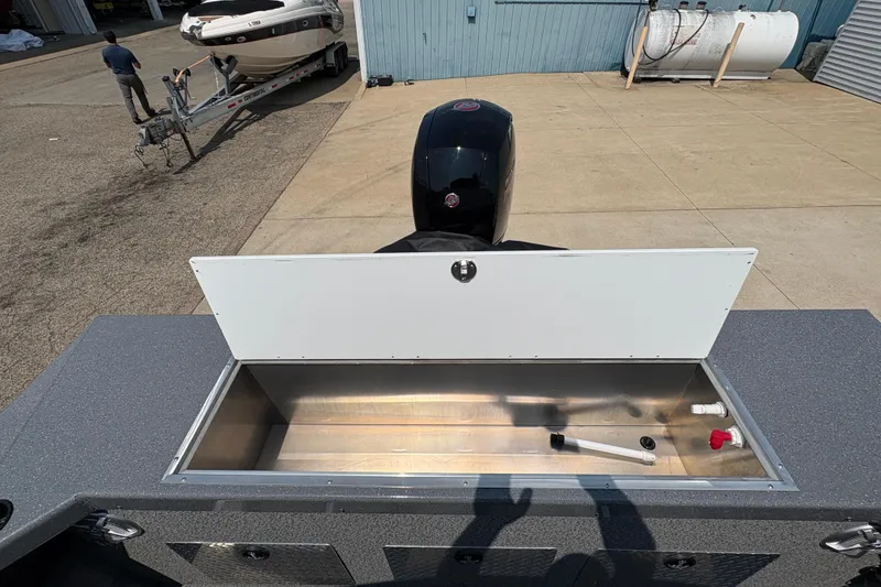 Slide: The Image of 2026 Lund 185 HG boat with open storage compartment and visible outboard motor. - 33