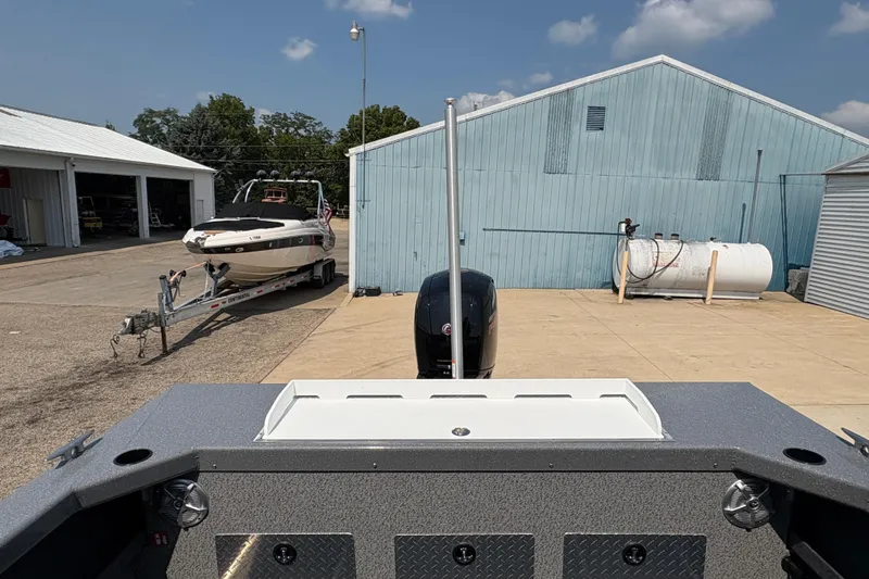 Slide: The Image of 2026 Lund 185 HG boat at dock with trailer and buildings in background. - 34
