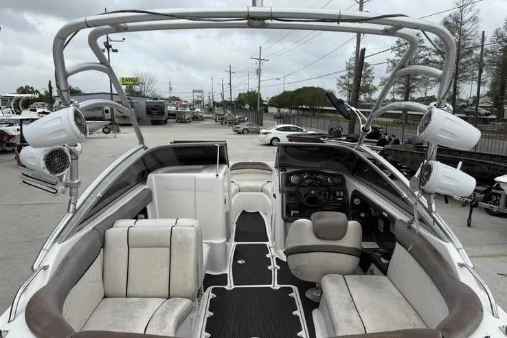 Slide: The Image of 2007 Yamaha AR 230 boat interior with seating and control panel, parked in a marina. - 10