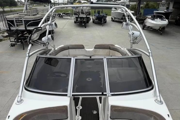 Slide: The Image of 2007 Yamaha AR 230 boat with sleek design and spacious seating, docked at a marina. - 13