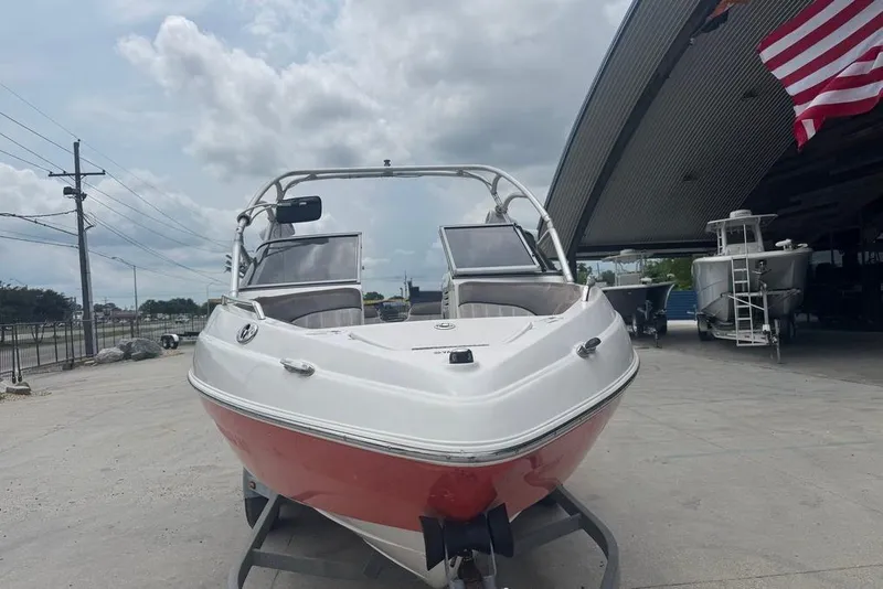 Slide: The Image of 2007 Yamaha AR 230 boat with red hull, parked outdoors under cloudy sky. - 5