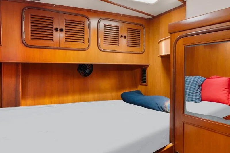 Slide: The Image of Cozy cabin interior of 1996 Tayana 58 yacht with wooden finish and comfortable bedding. - 12