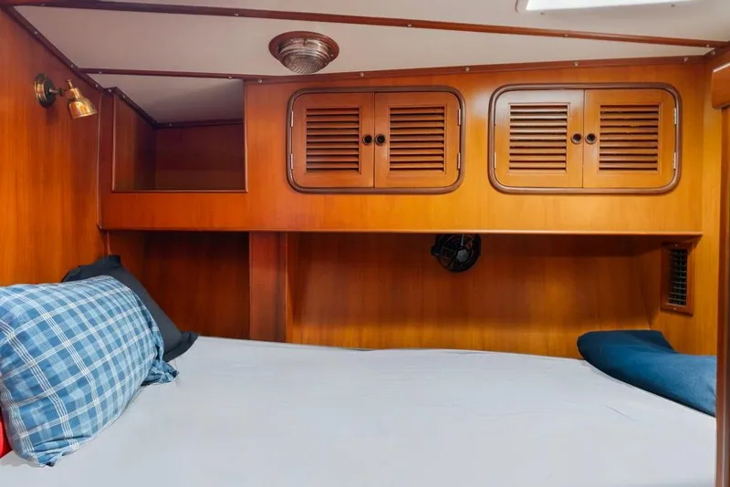 Slide: The Image of Cozy cabin interior of 1996 Tayana 58 yacht with wooden finish and comfortable bedding. - 13