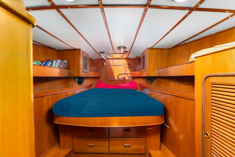 Slide: The Image of Cozy cabin interior of 1996 Tayana 58 yacht with wooden furnishings and blue bedding. - 14