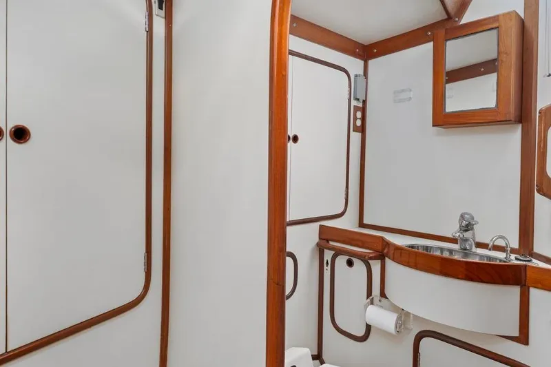 Slide: The Image of Bathroom interior of 1996 Tayana 58 yacht with wooden accents and stainless steel sink. - 16