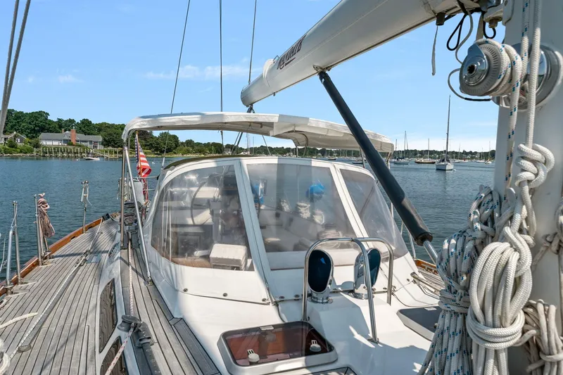 Slide: The Image of 1996 Tayana 58 sailboat docked in a scenic marina with clear skies. - 21